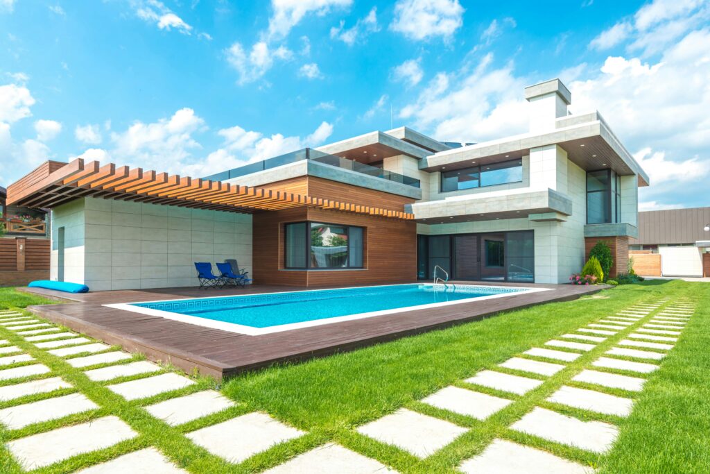 Modern luxury home with a private backyard pool featuring clear blue water, showing how to make the pool crystal clear through proper care and upkeep.