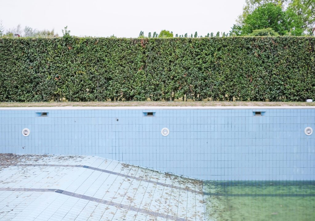 Backyard swimming pool drained for maintenance work, providing context for how much does a pool cost